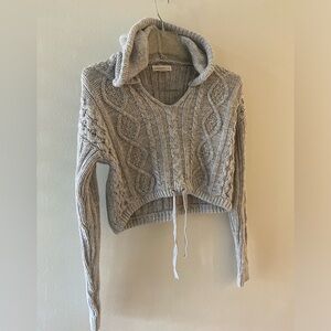 Cute grey sweater with a hoodie. It is a crop fit!